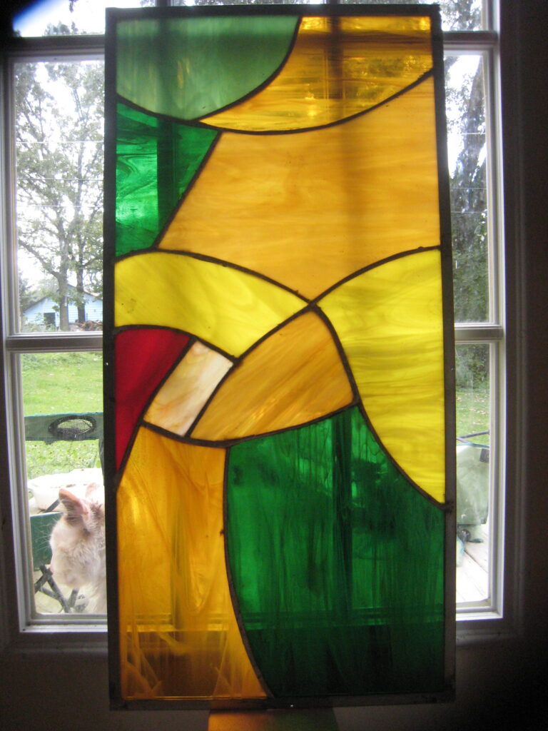 Abstract stained-glass panel in green, yellow, orange, and cream
