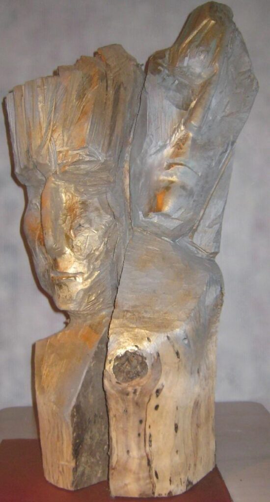 Carved wooden abstract figure with a pale textured surface