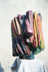 Colorfully painted abstract head sculpture on a white pedestal