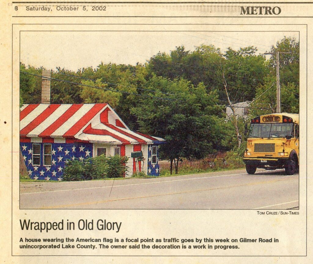 Newspaper clipping titled Wrapped in Old Glory, dated October 5, 2002