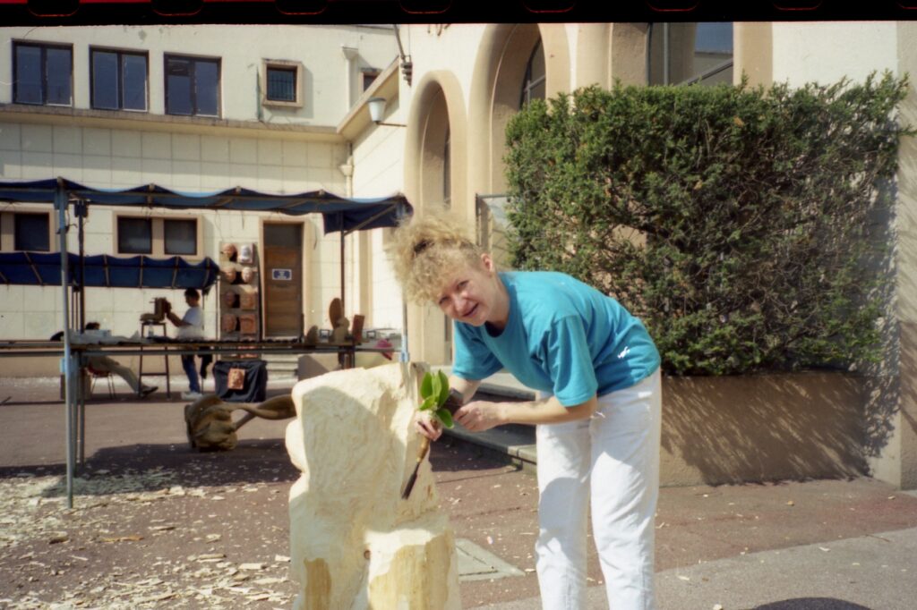 Artist carving a pale block outdoors