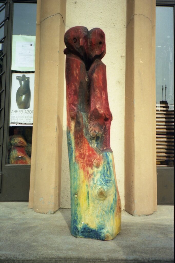 Two tall painted sculptures displayed in a gallery