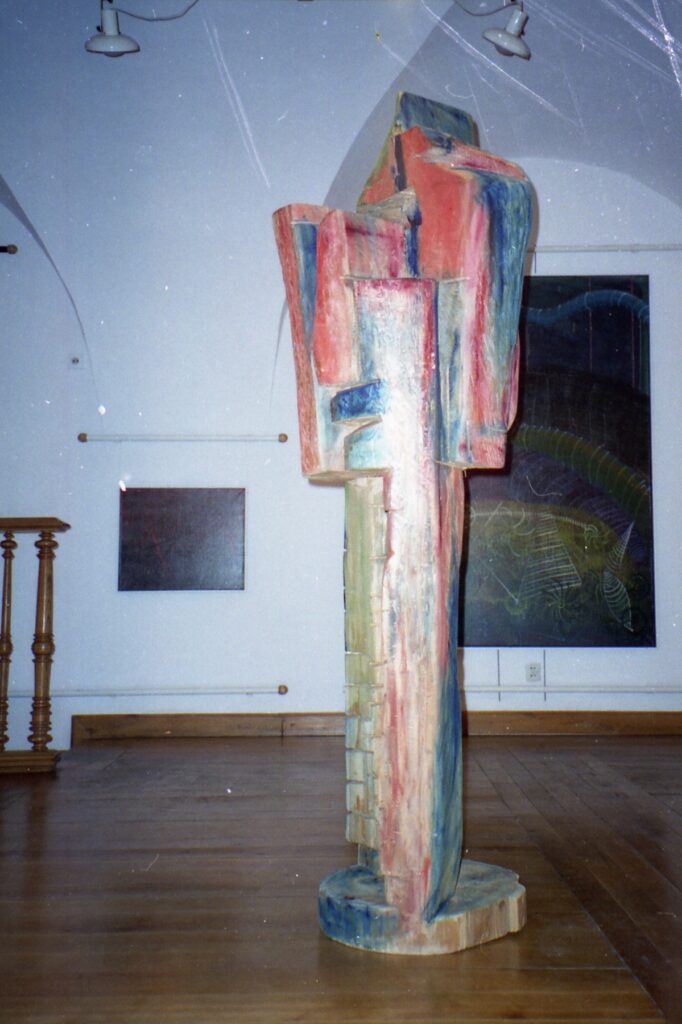 Tall painted sculpture displayed in a gallery