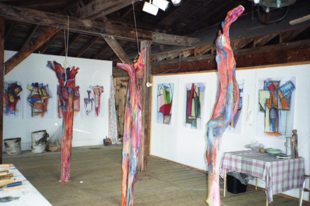 Archival installation detail with painted sculptures and works arranged on white walls